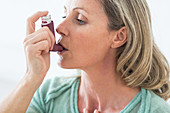 Woman using an aerosol inhaler