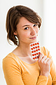 Woman taking food supplement capsules