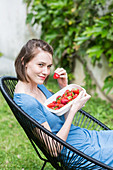 Young woman eating strawberries