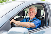 Senior driving his car