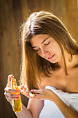 Woman applying oil on the tip of the hair
