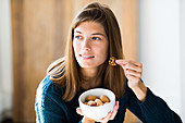Woman eating several nuts
