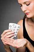 Woman taking statin cholesterol-lowering pills