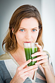 Woman drinking a wheat grass juice