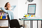 Office woman stretching arms at work