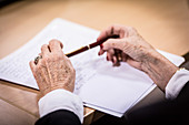 Hands of elderly woman holding a pen