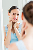 Woman checking her face in the mirror
