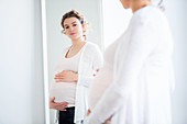 Pregnant woman looking in the mirror
