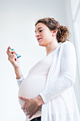 Pregnant woman using an asthma inhaler