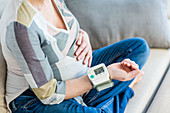 Pregnant woman taking her blood pressure