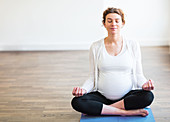 Pregnant woman meditating in a yoga pose