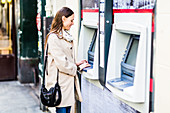 Woman withdrawing money from a cash machine