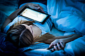 Woman using a digital tablet and phone at night