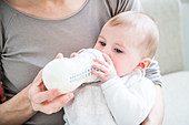 Baby girl drinking milk from a bottle