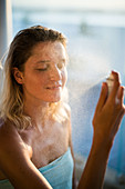 Woman spraying water on her face