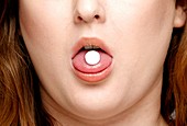 Pill on a woman's tongue