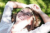 Woman lying on grass wearing daisy chain