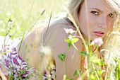 Woman lying in meadow with wild flowers
