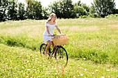 Young woman riding bicycle in field