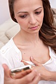 Woman checking her breast with smartphone