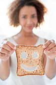 Woman holding bread with smiley face
