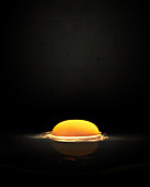 Raw egg yolk against black background