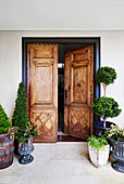 Entrance area with antique wooden door and box tree