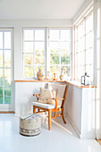 Wooden armchair and footstool in bright conservatory