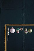 Old Christmas decorations hung in gilt picture frame