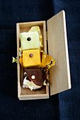 Petit fours with gold foil in a wooden box