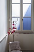 Mit Blumen dekorierte Büste aus Draht vor einem Fenster