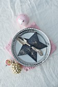 Paper star-shaped cutlery holder on plate with vintage decorations