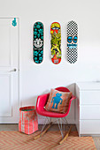 Three skateboards over a red designer rocking chair
