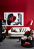 Black coffee table, black cupboard and bright sofa in the living room with red wall