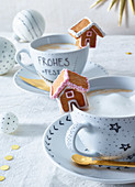 A gingerbread house on a cappuccino cup