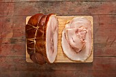 Roast ham, sliced, on a wooden board