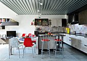 Küche und Essbereich mit Designerstühlen im Industrie-Loft
