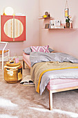 Rosa Daybed mit Bettwäsche, goldfarbener Beistelltisch und Wandschrank