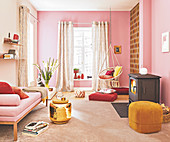 A daybed, a pouffe, a golden sidetable, a swing chair and a wood-burning stove in a pink decorated living room