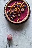 A raw plum and vanilla tart with blueberries