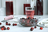 Cornelian cherries in a glass bowel and syrup in bottles