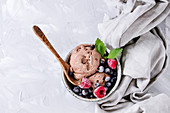 Homemade chocolate ice cream with frozen berries in a small bowl