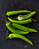 Green chilli peppers on a wooden surface