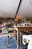 Wooden dining table and chairs on black-tiled floor in converted barn