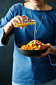 Süsskartoffel-Okra-Salat wird mit Honig-Senf-Dressing betäufelt
