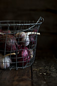 Garlic and red onions in a wire basket