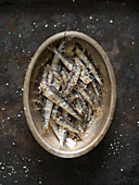 Fried sardines with salt in a metal dish
