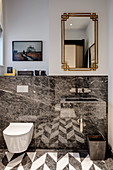 Patterned floor reflected in glossy stone wall cladding in bathroom