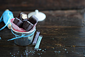 Chocolate-covered ice cream pralines in an ice bucket and blue and purple hundreds and thousands