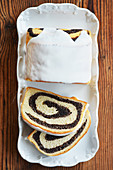 Poppy seed cake with icing and two slices cut off